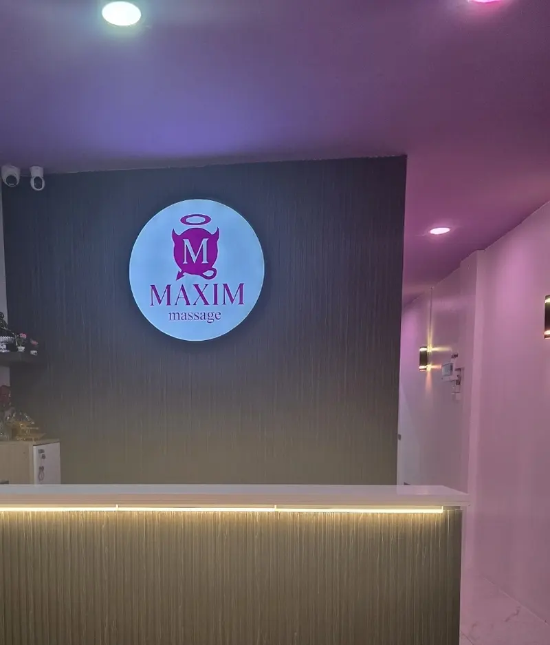 Reception desk with the illuminated MAXIM massage logo